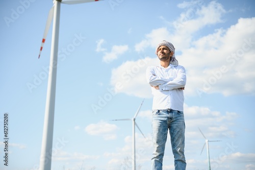 Indian Engineer in wheat field checking on turbine production © Serhii