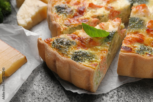 Delicious homemade quiche with salmon and broccoli on gray table, closeup