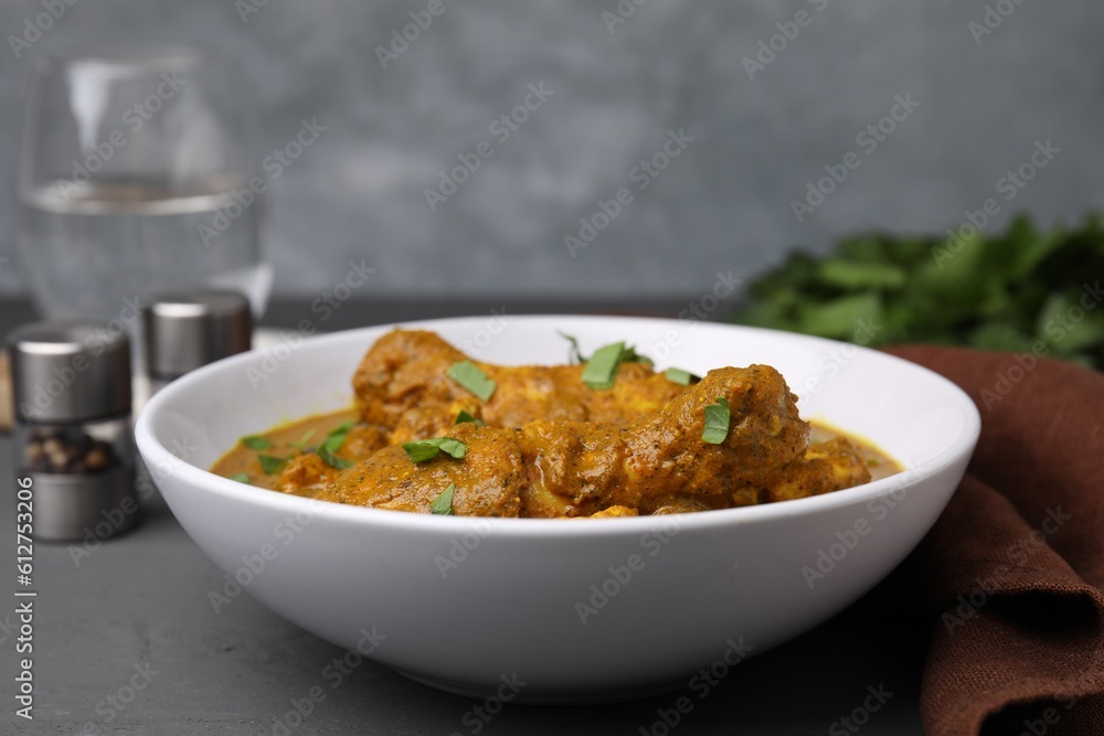 Delicious chicken with curry sauce on grey wooden table, closeup Delicious chicken with curry sauce on grey wooden table, closeup