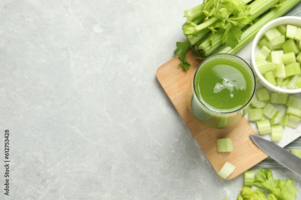 Glass of delicious celery juice and vegetables on grey table, flat lay. Space for text Glass of delicious celery juice and vegetables on grey table, flat lay. Space for text