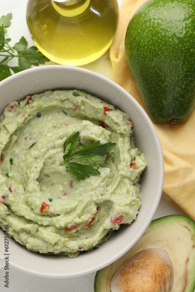 Delicious guacamole and ingredients on white table, flat lay Delicious guacamole and ingredients on white table, flat lay