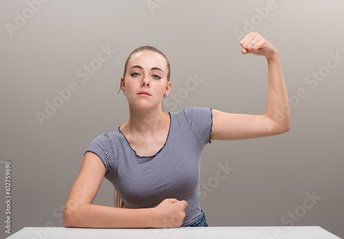 Tableau sur toile Strong woman flexes muscle, defiant