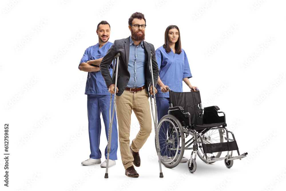 Male and female health care workers in blue uniforms posing behind a bearded man Male and female health care workers in blue uniforms posing behind a bearded man