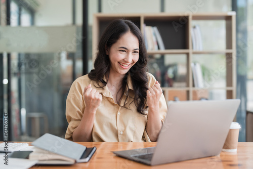 Happy asian business woman employee celebrating while reading email good news. business account and finance