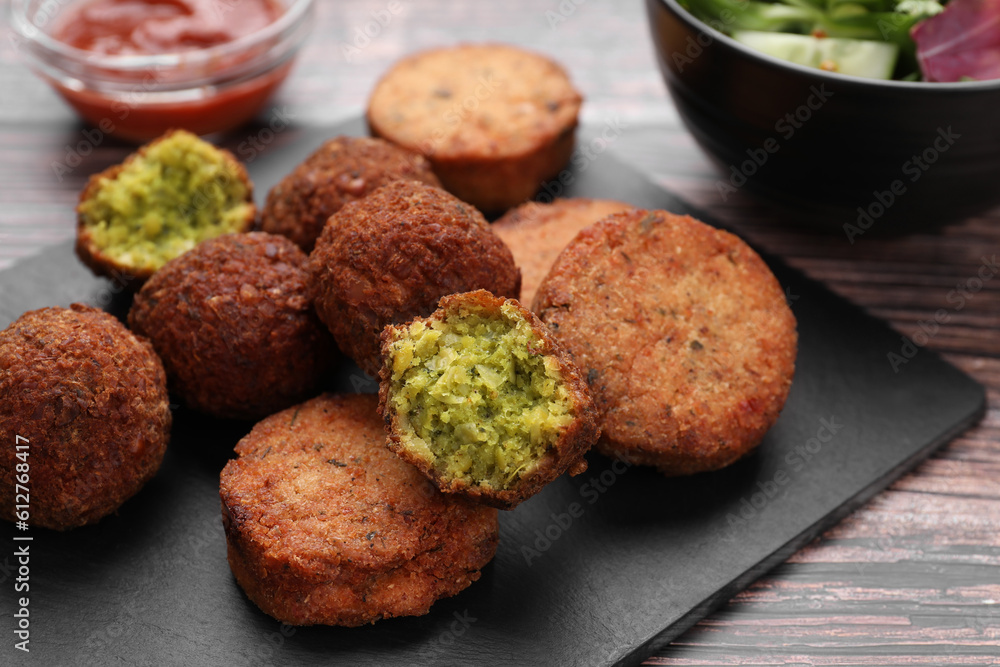 Delicious vegan cutlets and falafel balls on wooden table, closeup Delicious vegan cutlets and falafel balls on wooden table, closeup