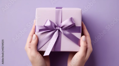 Female hands hold a gift box with a bow. Surprise preparation. Christmas Eve, Xmas and New Year postcard. Black Friday sales, Birthday celebration party concept. © tashechka