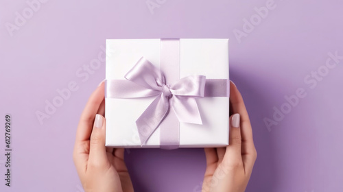 Female hands hold a gift box with a bow. Surprise preparation. Christmas Eve, Xmas and New Year postcard. Black Friday sales, Birthday celebration party concept. © tashechka