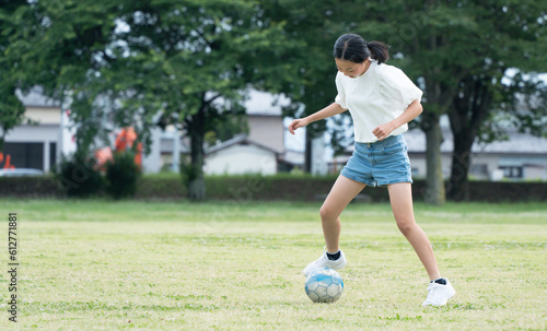 公園でサッカーをする小学生の女の子