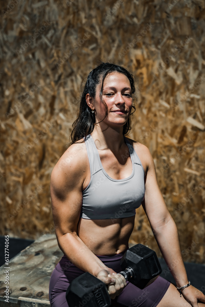 woman doing an arm workout in a crossfit gym.