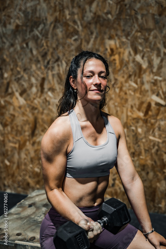 Obraz na płótnie woman doing an arm workout in a crossfit gym. w salonie