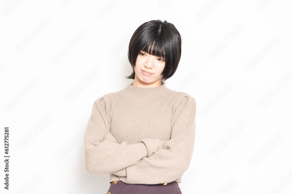 白背景の前で考え事をしている若い女性