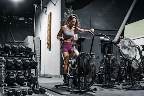 Obraz na płótnie woman doing cardio on the crossfit bike w salonie