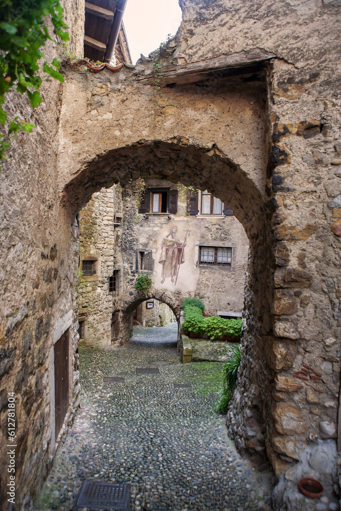 Via Fratelli Bandiera, a narrow lane through tunnel arches, Canale di Tenno, Trentino-Alto Adige, Italy.  Tenno is  included in the list of the most beautiful villages in Italy