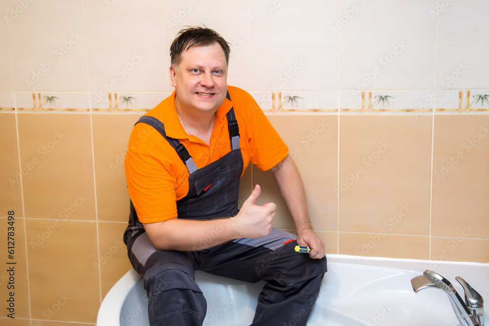 The plumber is busy installing new bathtub. The plumber is busy installing new bathtub.