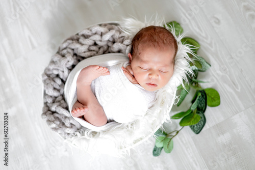close-up of a newborn baby girl in a diaper on a light background sleeping sweetly in a cute basket, the birth of a baby, a happy family