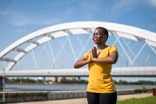 Young  sporty woman enjoys meditating outdoor. © inesbazdar