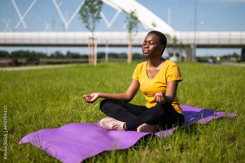 Fototapeta premium Young woman enjoys meditating outdoor.