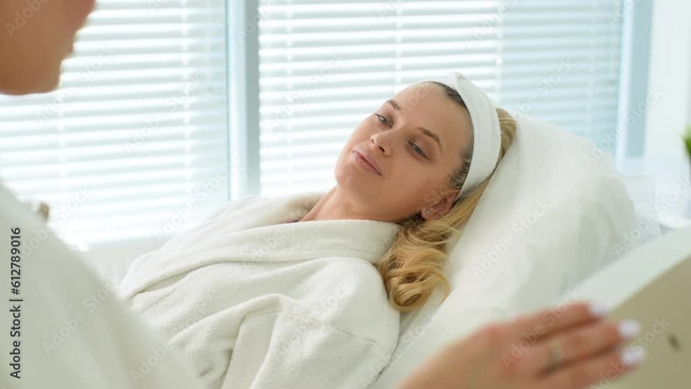 Close-up portrait of pretty young woman patient talking to doctor during health checkup at medic clinic. Illness blonde female lying on medical couch in examination room. Shooting in slow motion. Close-up portrait of pretty young woman patient talking to doctor during health checkup at medic clinic. Illness blonde female lying on medical couch in examination room. Shooting in slow motion.