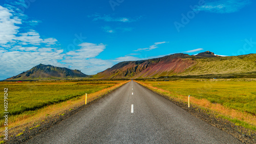 Panoramic over a paved road and Icelandic colorful and wild landscape with fjords and sea at summer time, West Iceland