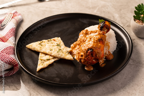 Butter Chicken with Rice and Naan Bread on a Black Plate 