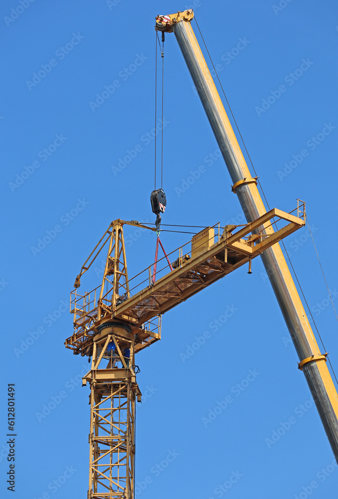 Tower crane under assembly against sky Tower crane under assembly against sky