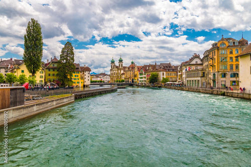 Lovely view of Lucerne's old town with the Needle Dam or Reuss Weir looking upriver. The famous Jesuit Church (Jesuitenkirche St. Francis Xavier) can be seen at the riverfront.
