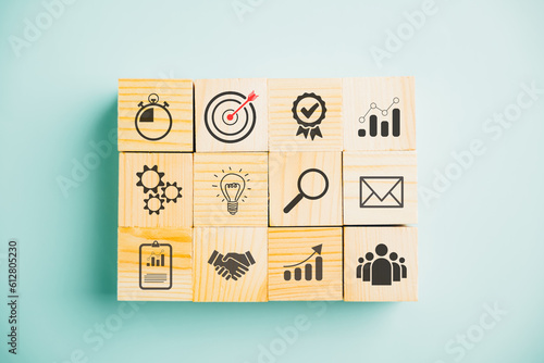 Business target concept with a wooden cube block step. Action Plan and Goal icons symbolize success. Project management and company strategy on a blue background.