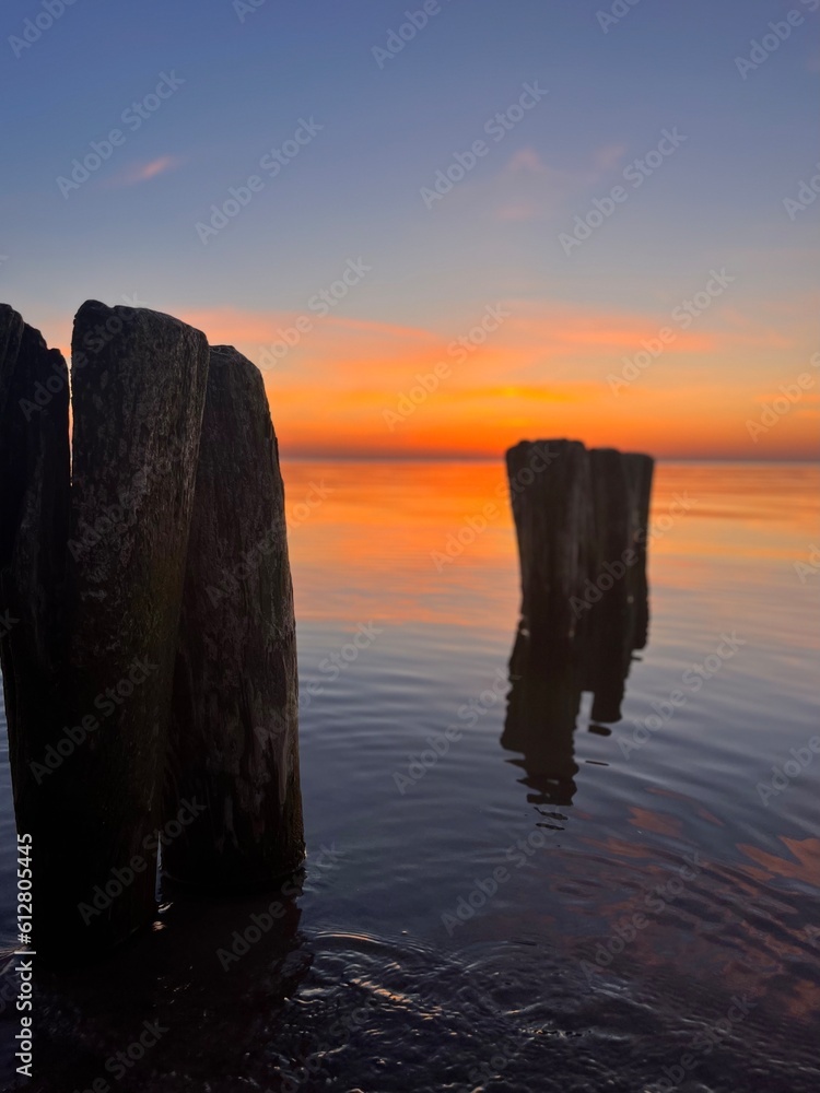 calm orange sea twilights, sky reflection on the city surface, evening seascape background