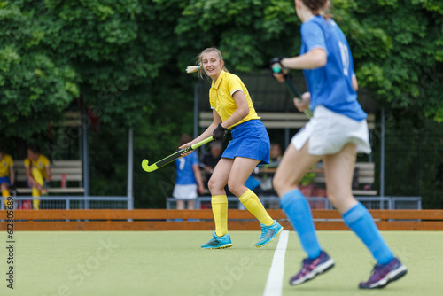 Young woman on the pitch playing field hockey game. © skumer