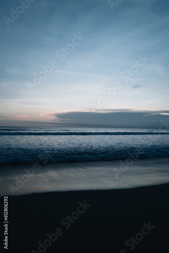 Amazing evening sunset dark blue sky on the Indian Ocean with waves on Bali island. Tropical summer background