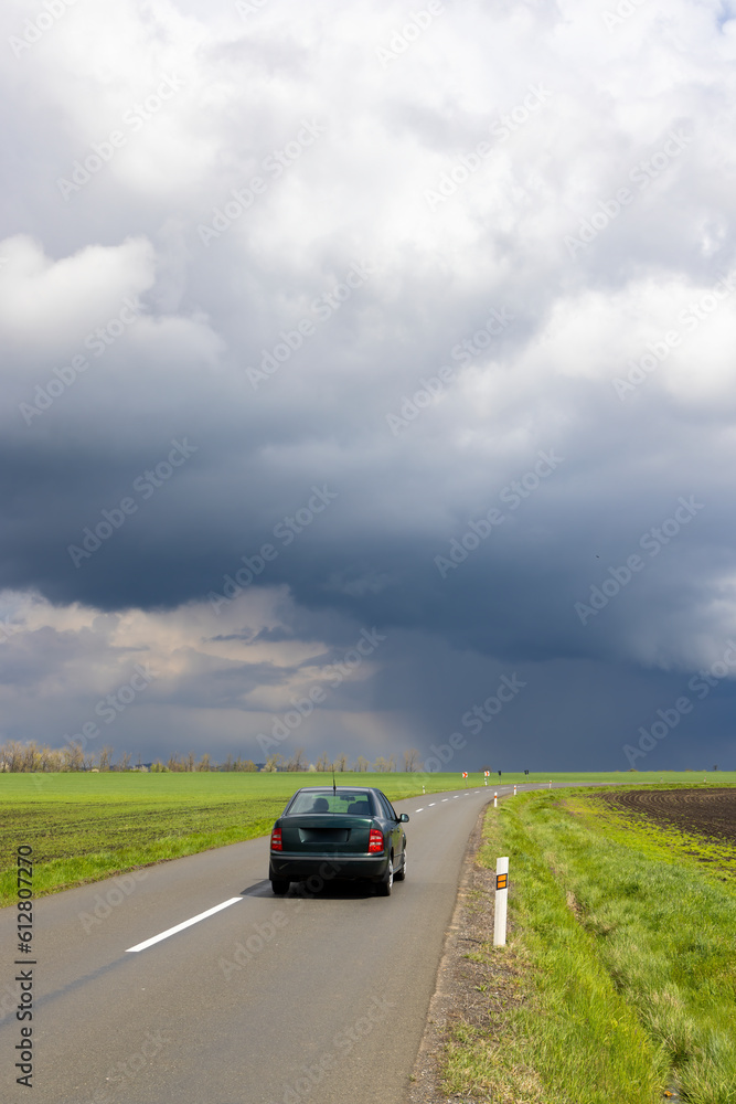 a car on the road with dramatic sky