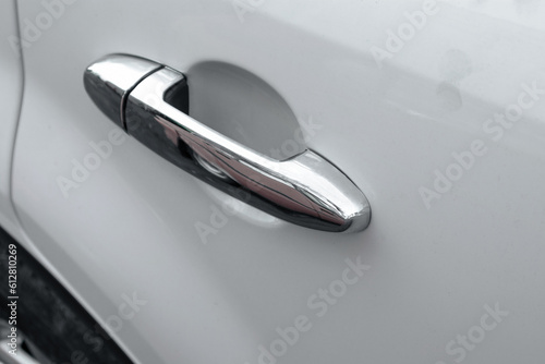 Chrome car door handle. Rear passenger door handle of a white car