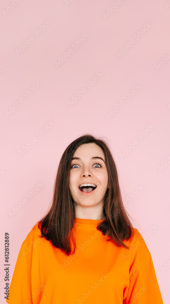 Fototapeta premium Energetic Expression: Impressed and Cheerful Woman with Open Mouth - Vibrant Emotion and Enthusiasm Captured on Pink Background