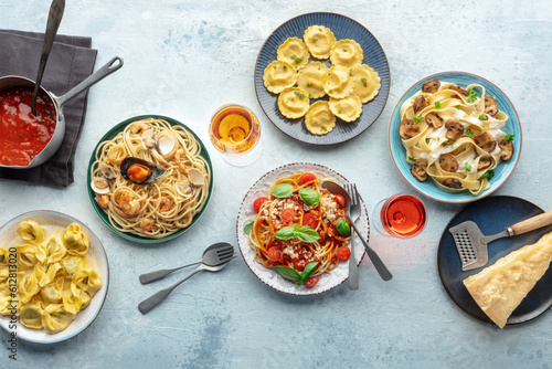 Pasta variety. Italian food and drinks, overhead flat lay shot. Spaghetti marinara, mushroom pappardelle, seafood pasta, wine, tomato sauce, Parmesan