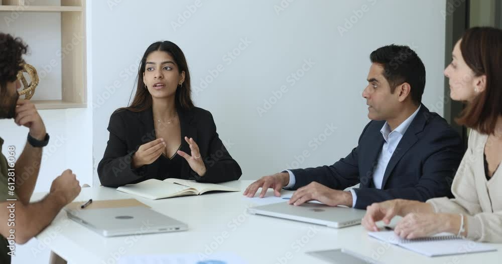 Young Indian businesswoman take part in group training with employees, lead formal meeting in conference room, give advice to workmates, discuss project, sales result, proposes solutions to problem Young Indian businesswoman take part in group training with employees, lead formal meeting in conference room, give advice to workmates, discuss project, sales result, proposes solutions to problem