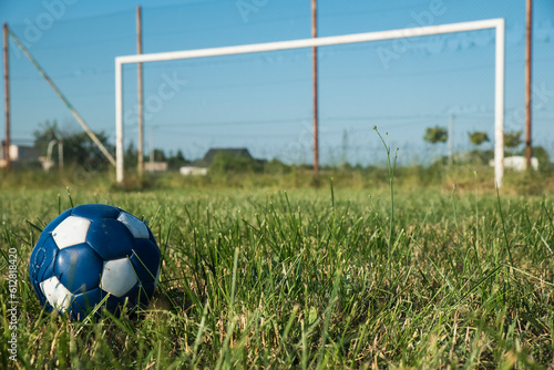 piłka nożna na tle nieczynnego boiska ligowego w słoneczny dzień © siwyk