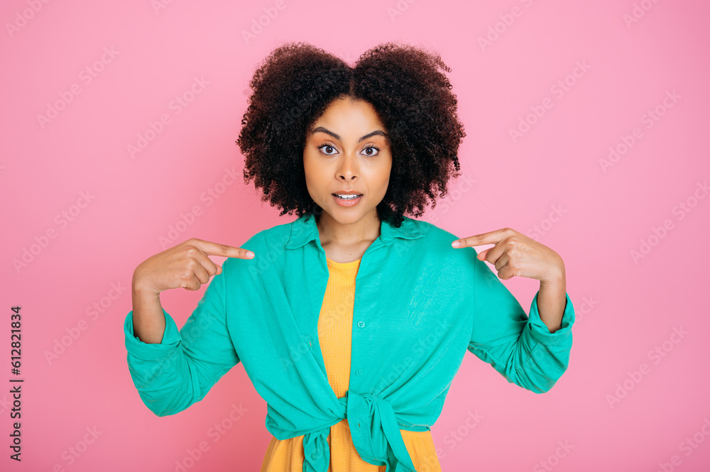Confused satisfied african american or brazilian woman, points at herself, asks something, didn't expect to be chosen, looks surprised at camera, stand on isolated pink background Confused satisfied african american or brazilian woman, points at herself, asks something, didn't expect to be chosen, looks surprised at camera, stand on isolated pink background