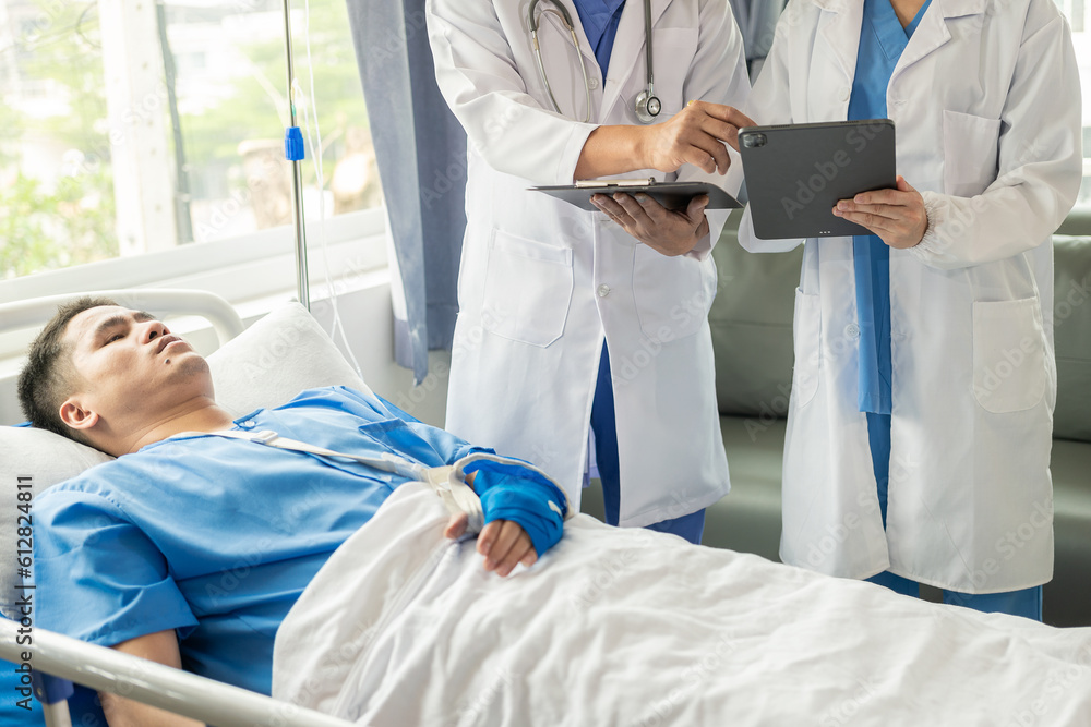 Two doctors talking to a patient lying in bed while receiving saline solution in hospital Professional medical service concept Attentive doctor comforting a patient Stock Picture Two doctors talking to a patient lying in bed while receiving saline solution in hospital Professional medical service concept Attentive doctor comforting a patient Stock Picture