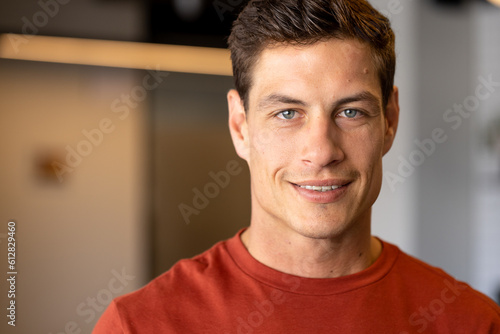 Portrait of happy caucasian casual businessman with blue eyes smiling in office