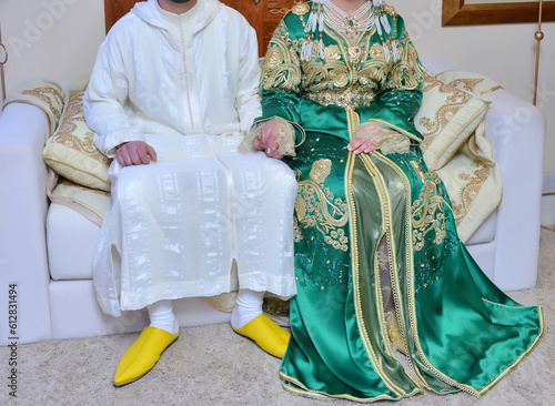 Moroccan wedding. A groom wearing a djellaba holds his bride who is wearing a traditional Moroccan caftan photo