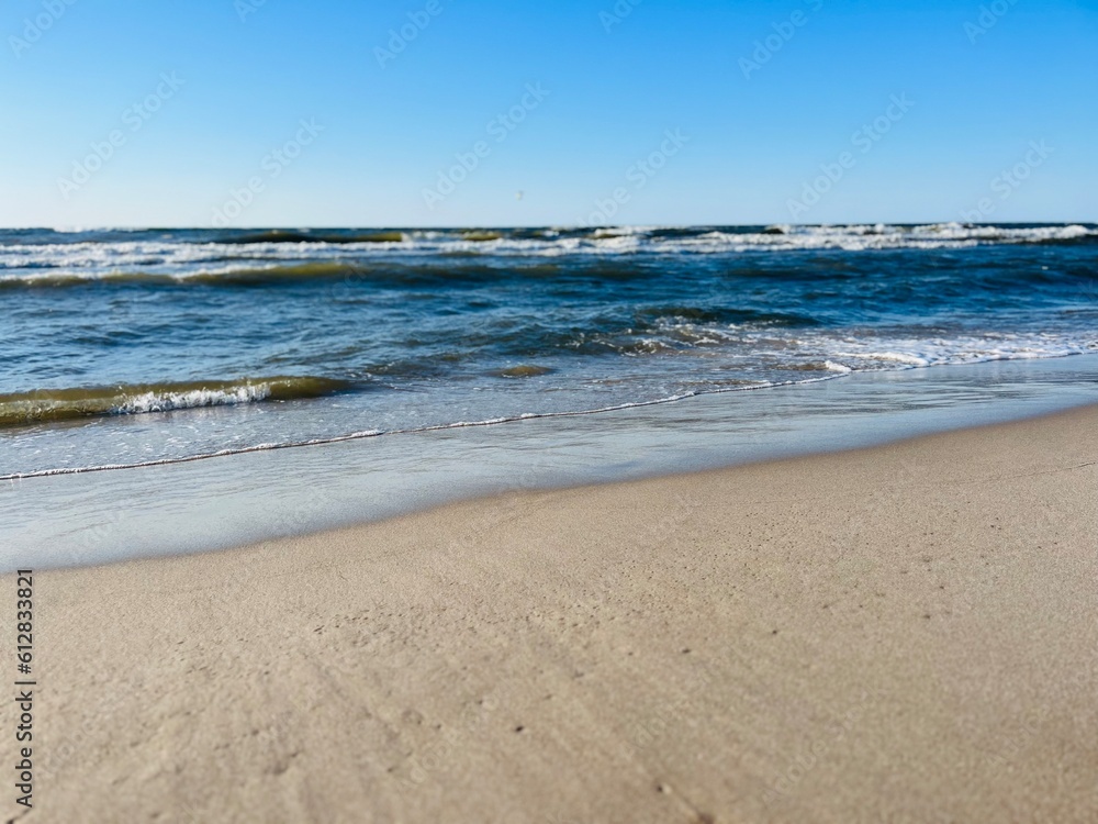 Blue seascape, waves on the sea, sandy coastline, empty beach