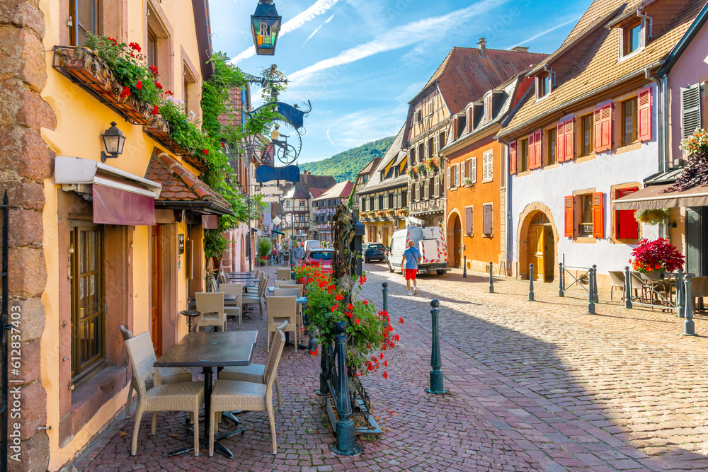Sidwalk cafes and shops line the picturesque streets of the village of Kaysersberg, France, one of the popular tourism stops along the Alsatian wine route.