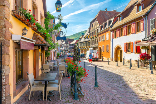 Sidwalk cafes and shops line the picturesque streets of the village of Kaysersberg  France  one of the popular tourism stops along the Alsatian wine route.