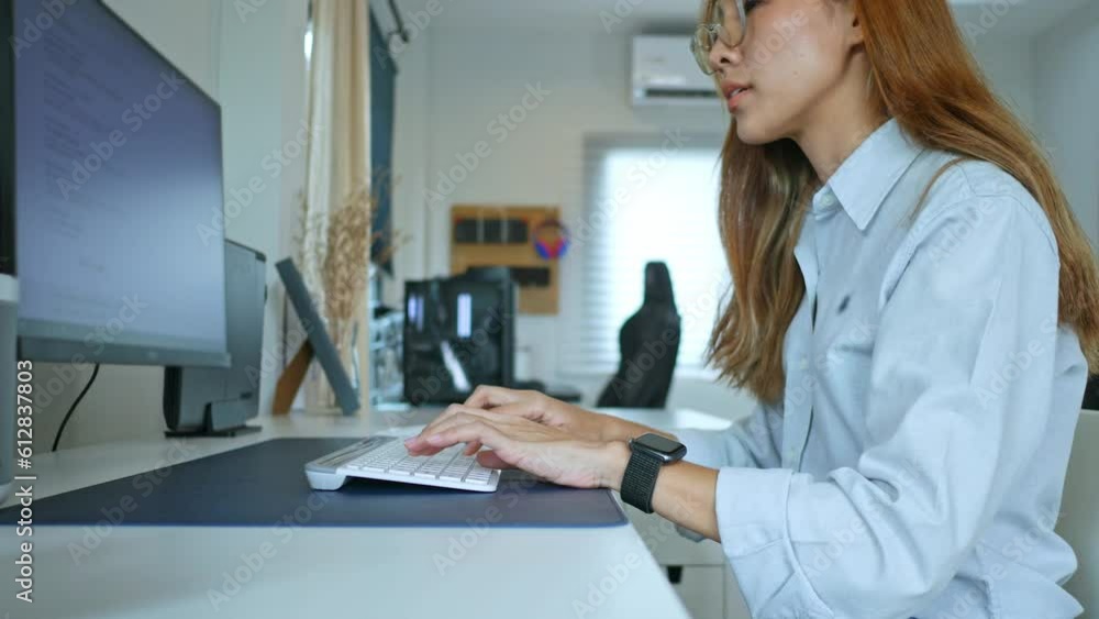 Young woman sitting and working in front of computer in her home, work from home concept, 4k video Young woman sitting and working in front of computer in her home, work from home concept, 4k video