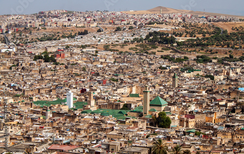 Aerial city view of the old Medina (downtown neighborhood) and the minaret of Zaouia Moulay Idriss II in Fez, Morocco, Africa. Rooftop view of Mosque towers and traditional Arabic townhouses. photo