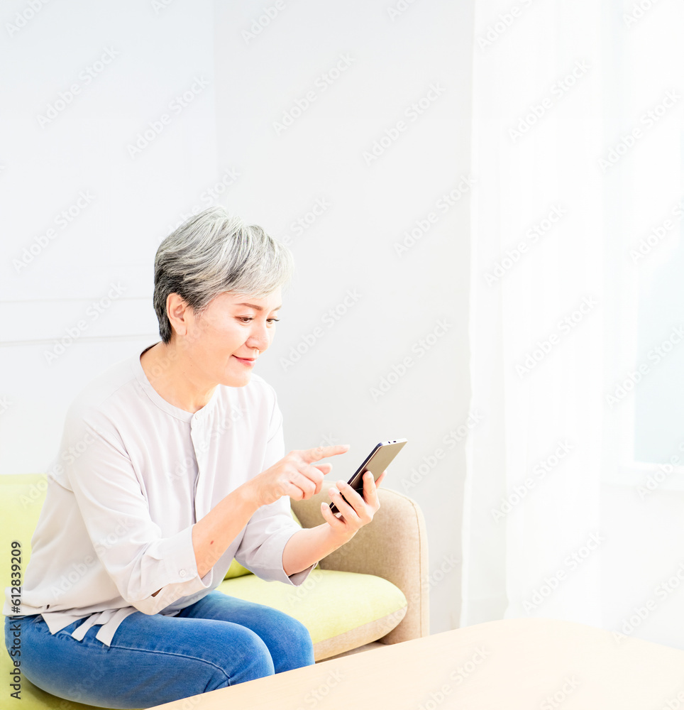 Senior asian woman holding smartphone using mobile online apps at home. Senior asian woman holding smartphone using mobile online apps at home.