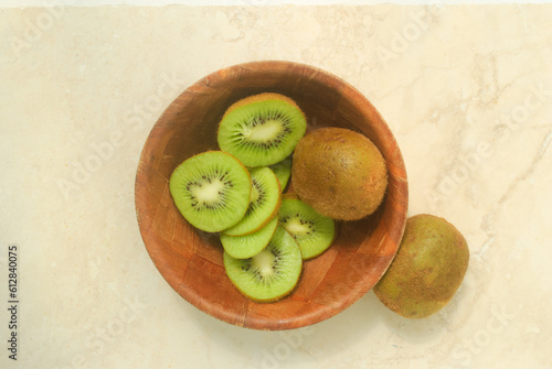 kiwi fruit on wooden bowl and kitchen top 