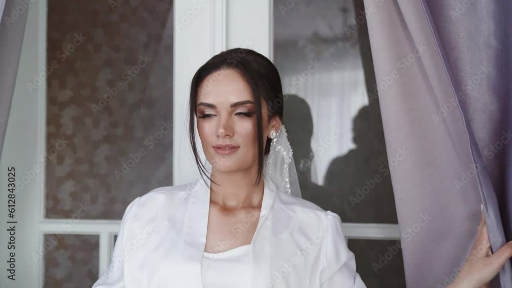 Stylish attractive bride is opening the curtains. Front close up view. Stylish attractive bride is opening the curtains. Front close up view.