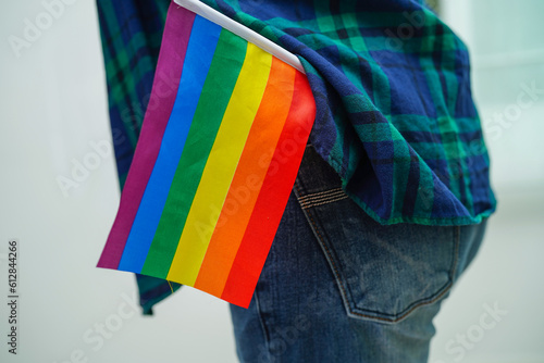Asian woman with rainbow flag, LGBT symbol rights and gender equality, LGBT Pride Month in June.
