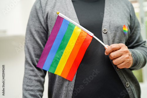 Asian woman with rainbow flag, LGBT symbol rights and gender equality, LGBT Pride Month in June.